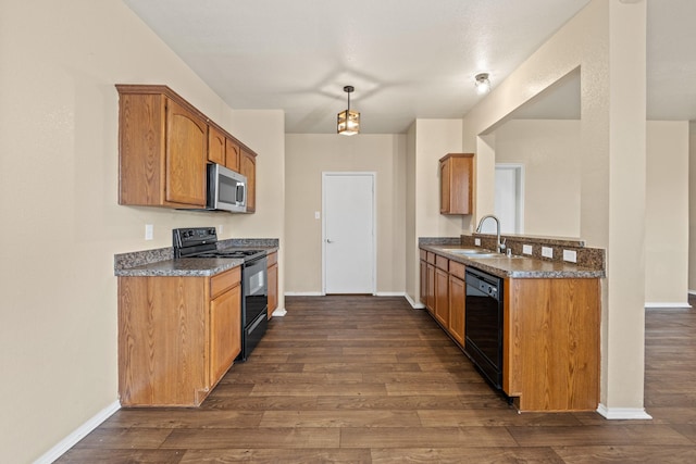 kitchen featuring brown cabinetry, baseboards, dark wood-type flooring, a sink, and black appliances
