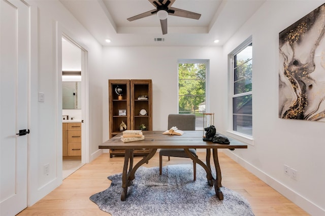 office featuring ceiling fan, visible vents, light wood finished floors, a tray ceiling, and recessed lighting
