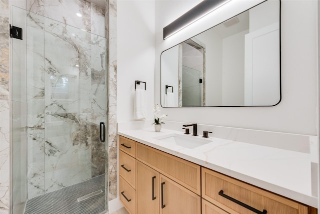 full bath featuring vanity and a marble finish shower