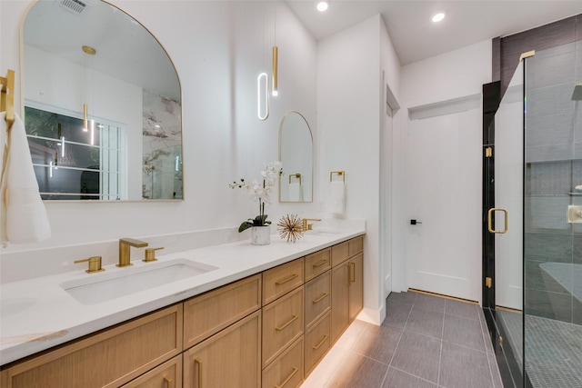 bathroom featuring double vanity, visible vents, a stall shower, a sink, and tile patterned floors