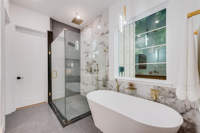 bathroom with tile patterned flooring, a freestanding tub, tile walls, and a shower stall