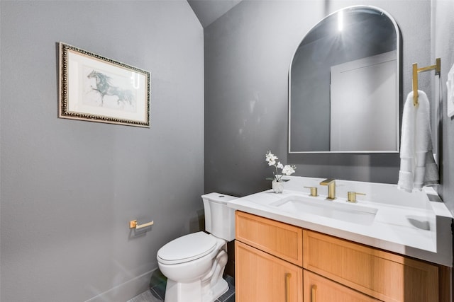 bathroom featuring vanity, baseboards, and toilet