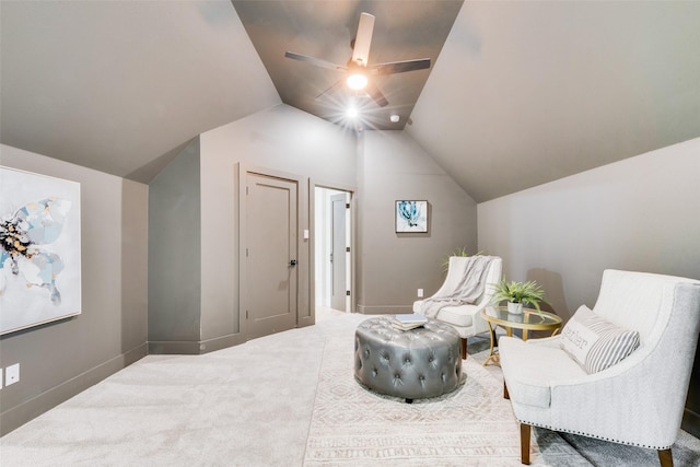 living area featuring baseboards, ceiling fan, carpet flooring, and lofted ceiling
