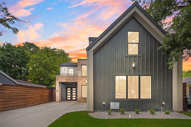 view of front facade with board and batten siding, french doors, and concrete driveway