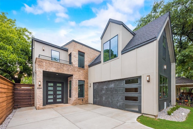 contemporary home featuring brick siding, fence, a balcony, concrete driveway, and a shingled roof