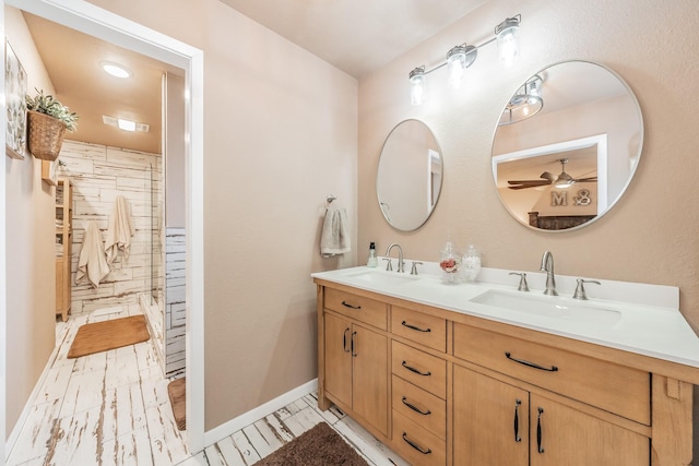 full bath with double vanity, a sink, a ceiling fan, and a shower