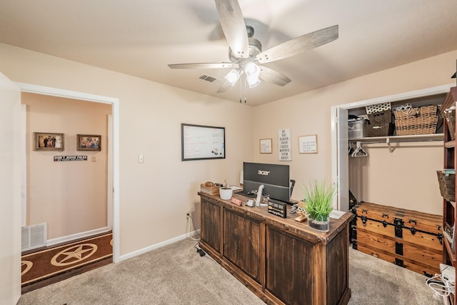 office featuring light colored carpet, a ceiling fan, and visible vents