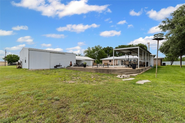 view of yard featuring a patio, a pole building, and an outdoor structure