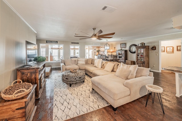 living room featuring visible vents, ornamental molding, ceiling fan, and wood finished floors