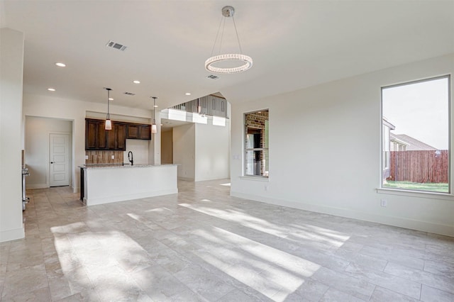 929 Ryed Ln, Fort Worth, TX 76120 - unfurnished living room featuring baseboards, a wealth of natural light, recessed lighting, and visible vents