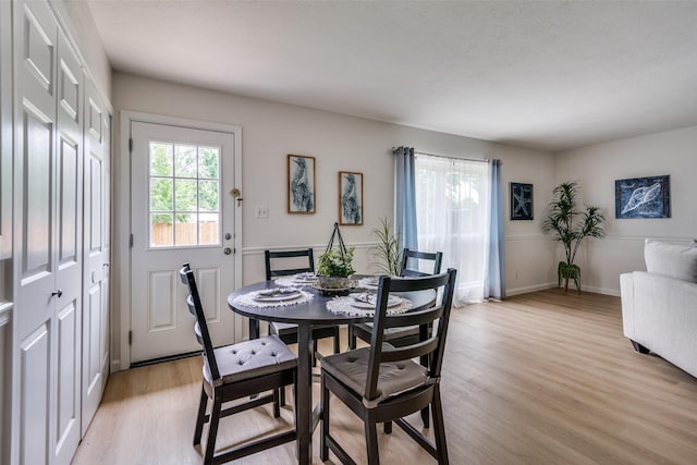 dining area featuring baseboards and light wood finished floors
