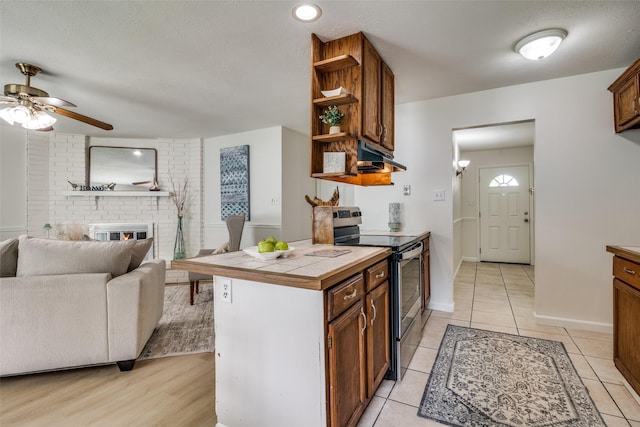 kitchen featuring open shelves, stainless steel range with electric stovetop, open floor plan, under cabinet range hood, and a ceiling fan