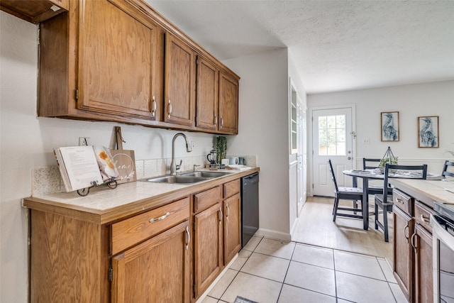 kitchen featuring black dishwasher, tile countertops, brown cabinets, and a sink