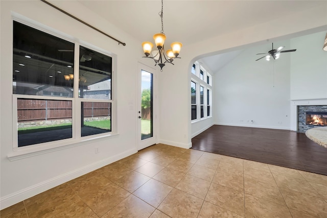 6917 Moody Ave, Frisco, TX 75035 - unfurnished dining area featuring vaulted ceiling, a chandelier, tile patterned flooring, a stone fireplace, and a ceiling fan