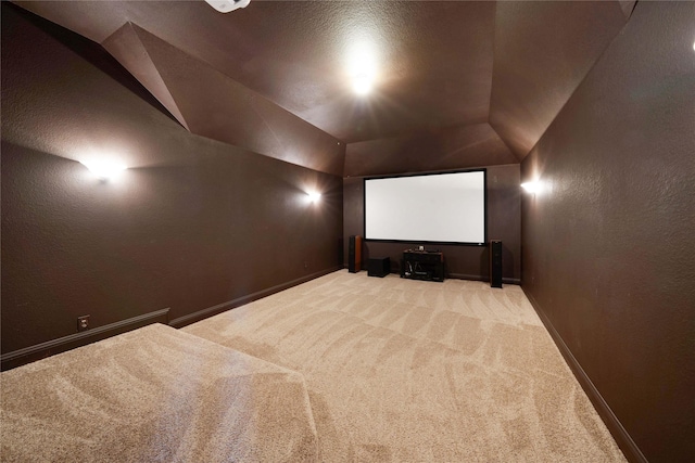 cinema featuring lofted ceiling, baseboards, carpet, and a textured wall