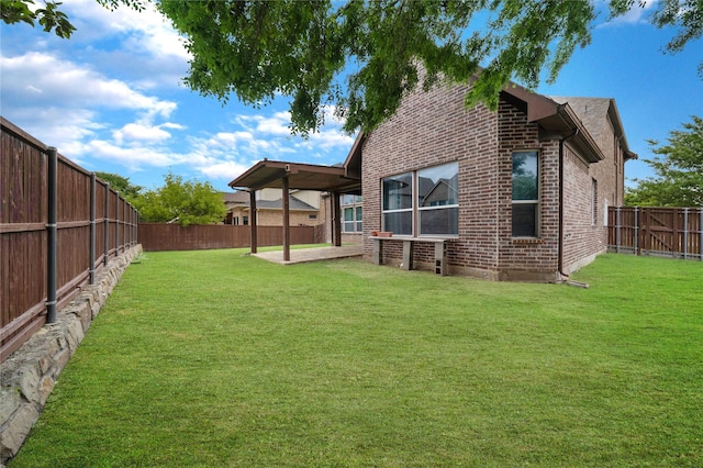 rear view of property featuring a fenced backyard, a patio, brick siding, and a lawn