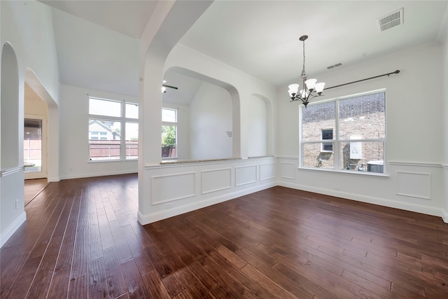6917 Moody Ave, Frisco, TX 75035 - unfurnished room with a chandelier, dark wood-style flooring, a wainscoted wall, and arched walkways