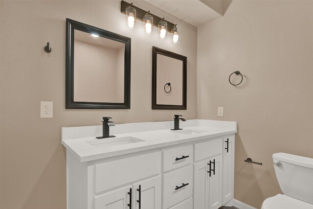 703 S Montgomery St, Sherman, TX 75090 - bathroom with double vanity, toilet, and baseboards