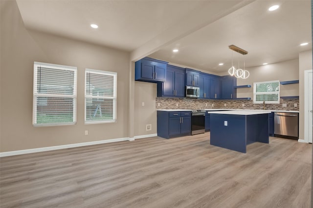 703 S Montgomery St, Sherman, TX 75090 - kitchen with stainless steel appliances, open shelves, blue cabinetry, light countertops, and decorative backsplash