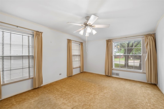 carpeted empty room with a ceiling fan, baseboards, visible vents, and ornamental molding