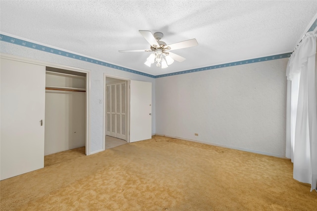 unfurnished bedroom with ceiling fan, carpet, and a textured ceiling