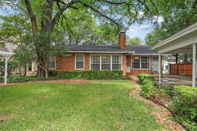 view of front of house with brick siding, fence, and a front yard