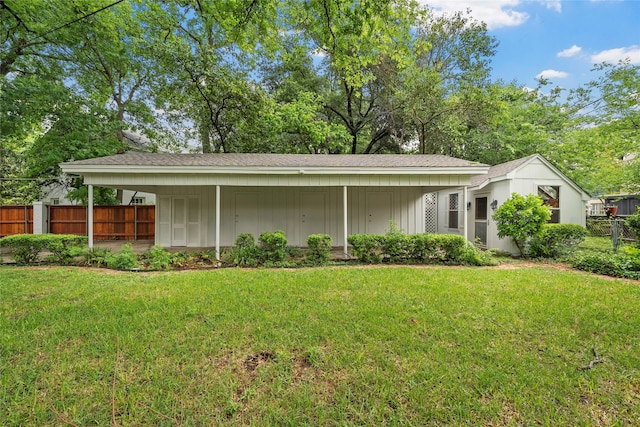 view of home's exterior featuring a yard, fence, a shingled roof, and board and batten siding