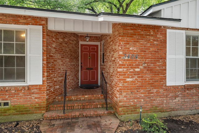 entrance to property featuring brick siding and board and batten siding