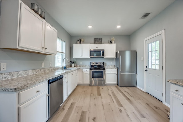 kitchen featuring visible vents, appliances with stainless steel finishes, a healthy amount of sunlight, and light wood finished floors