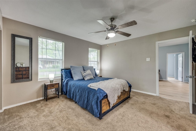bedroom with baseboards, ceiling fan, and light colored carpet