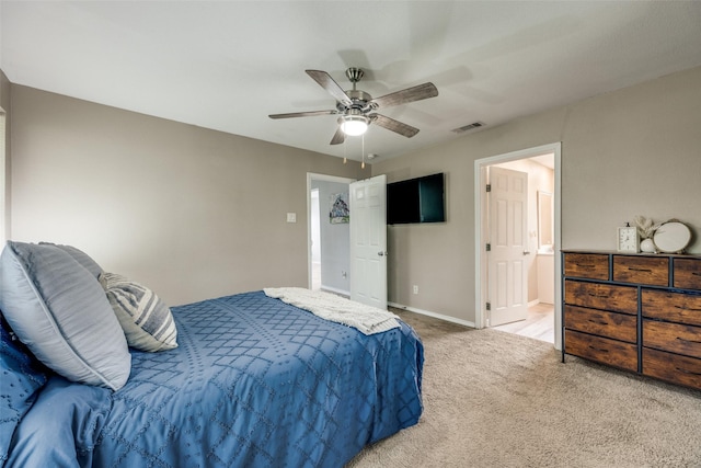 carpeted bedroom with visible vents, baseboards, ensuite bathroom, and ceiling fan