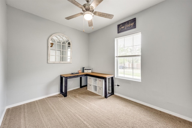 unfurnished office with baseboards, ceiling fan, and light carpet