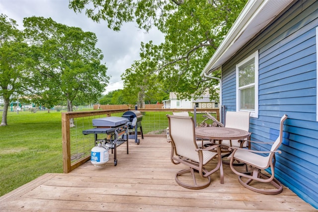 wooden deck with a yard, fence, and outdoor dining space