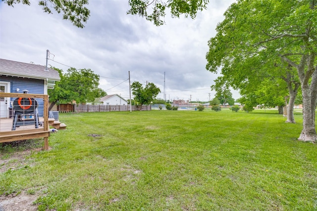 view of yard with a deck and fence