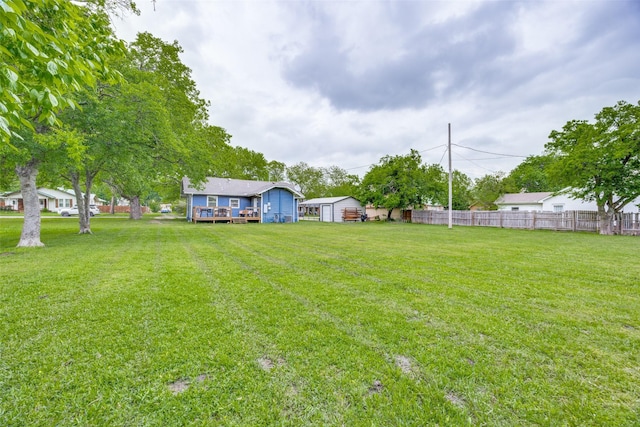 view of yard featuring a deck and fence