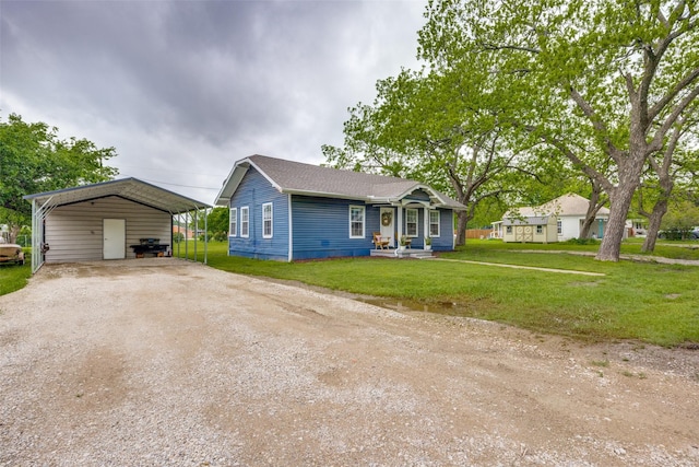bungalow-style home featuring a detached carport, driveway, and a front lawn