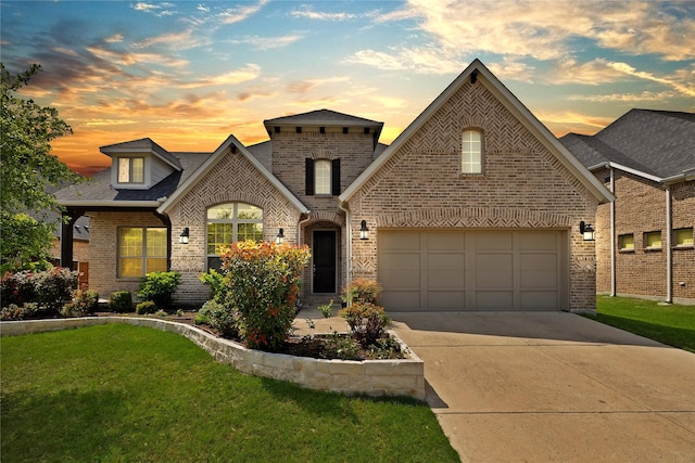view of front of house with a lawn, a shingled roof, concrete driveway, and brick siding
