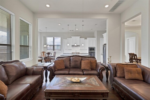 living room featuring recessed lighting, dark wood finished floors, and visible vents