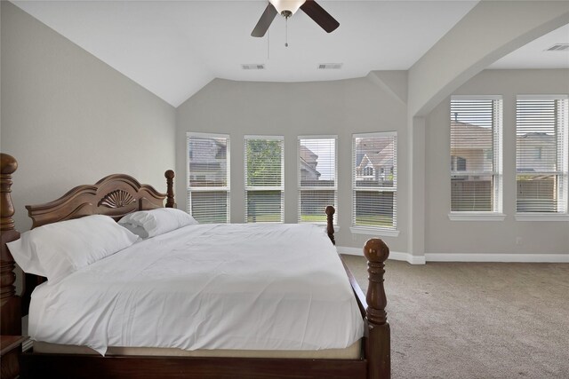 carpeted bedroom with arched walkways, baseboards, visible vents, and ceiling fan