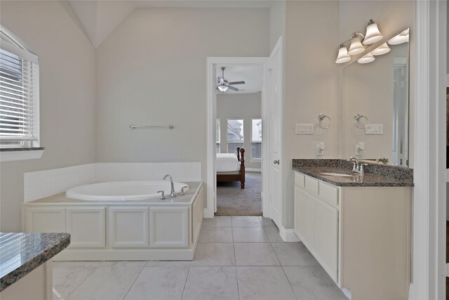 bathroom with vanity, lofted ceiling, ceiling fan, a bath, and ensuite bath