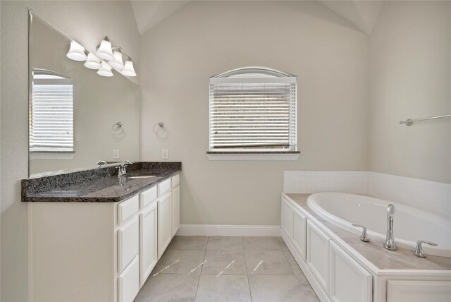 bathroom with vanity, plenty of natural light, baseboards, and a bath