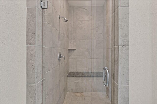 room details featuring a textured wall and a stall shower