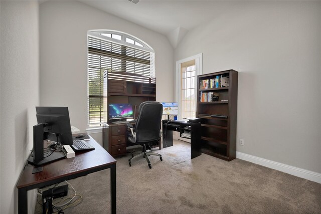 home office featuring light colored carpet, baseboards, and lofted ceiling