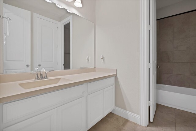 bathroom featuring baseboards, shower / bathing tub combination, tile patterned flooring, and vanity