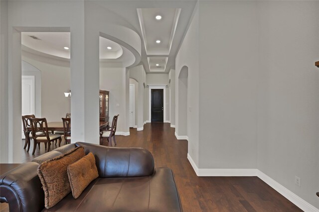 living area featuring arched walkways, baseboards, recessed lighting, and dark wood-type flooring
