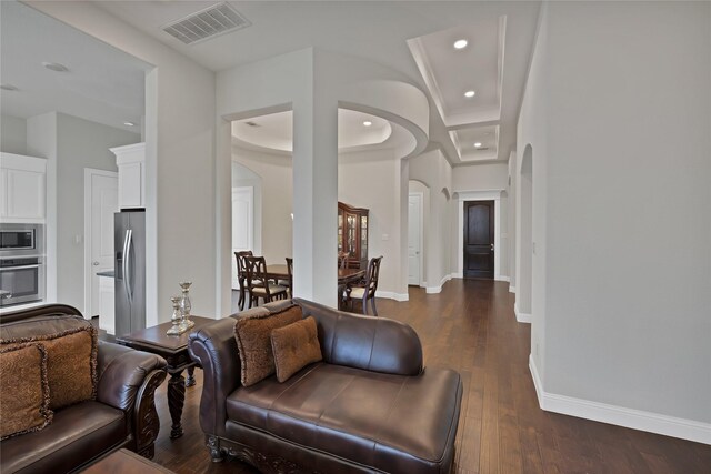 living area with visible vents, arched walkways, dark wood-style flooring, and recessed lighting