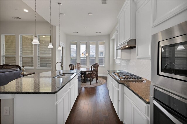 kitchen featuring visible vents, baseboards, under cabinet range hood, a sink, and stainless steel appliances