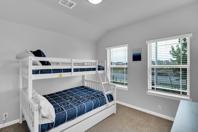 carpeted bedroom with visible vents, baseboards, and lofted ceiling