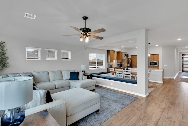 living room with ceiling fan, recessed lighting, baseboards, light wood-type flooring, and visible vents