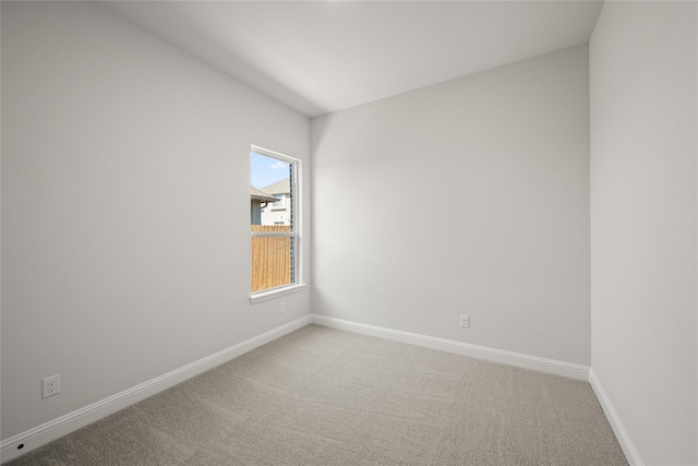 carpeted empty room featuring baseboards